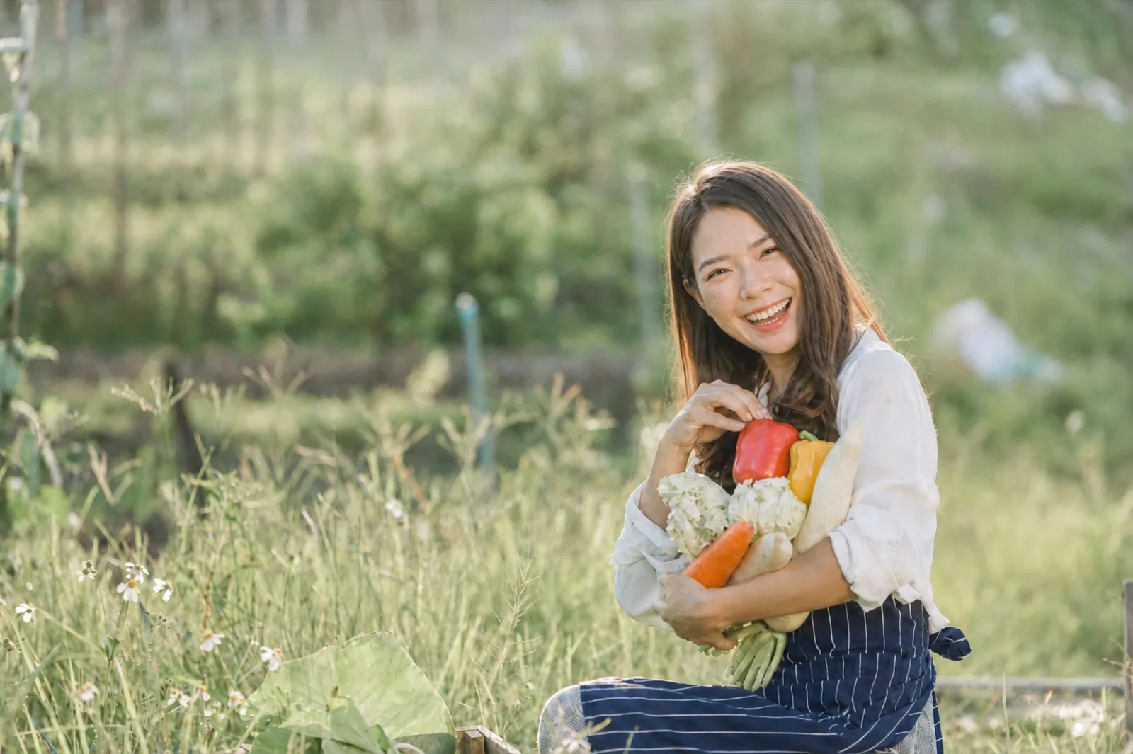 A farmer holding fresh seasonal produce — farm-to-table education at LOHERB Cuisine